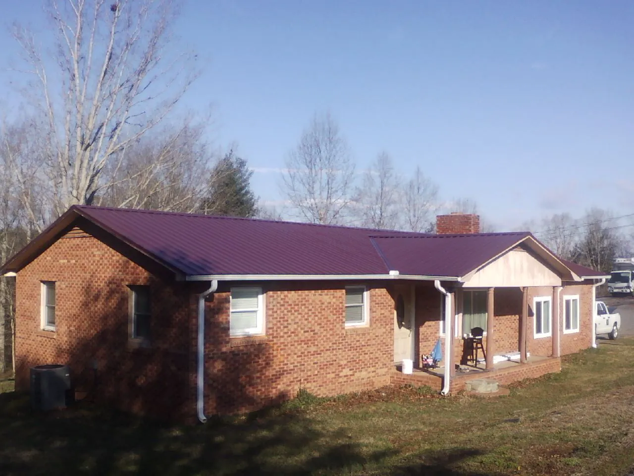 Burgundy metal roof on a brick ranch home with a new addition in Silver Springs