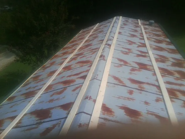 Rusted metal roof panels with new wood purlins before replacement — Storm Damage Roof Repair in Silver Springs by Roofing Brothers