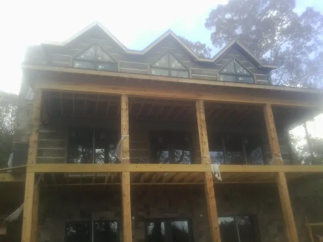 Dormers and porch framing on a large log home under construction — Roof Coating work by our crew in Silver Springs