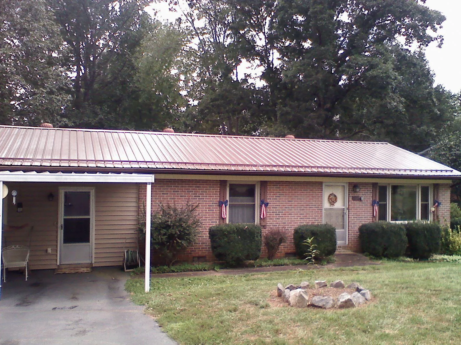 Bronze metal roof and carport on a brick ranch home — Roof Repair work by our crew in Silver Springs